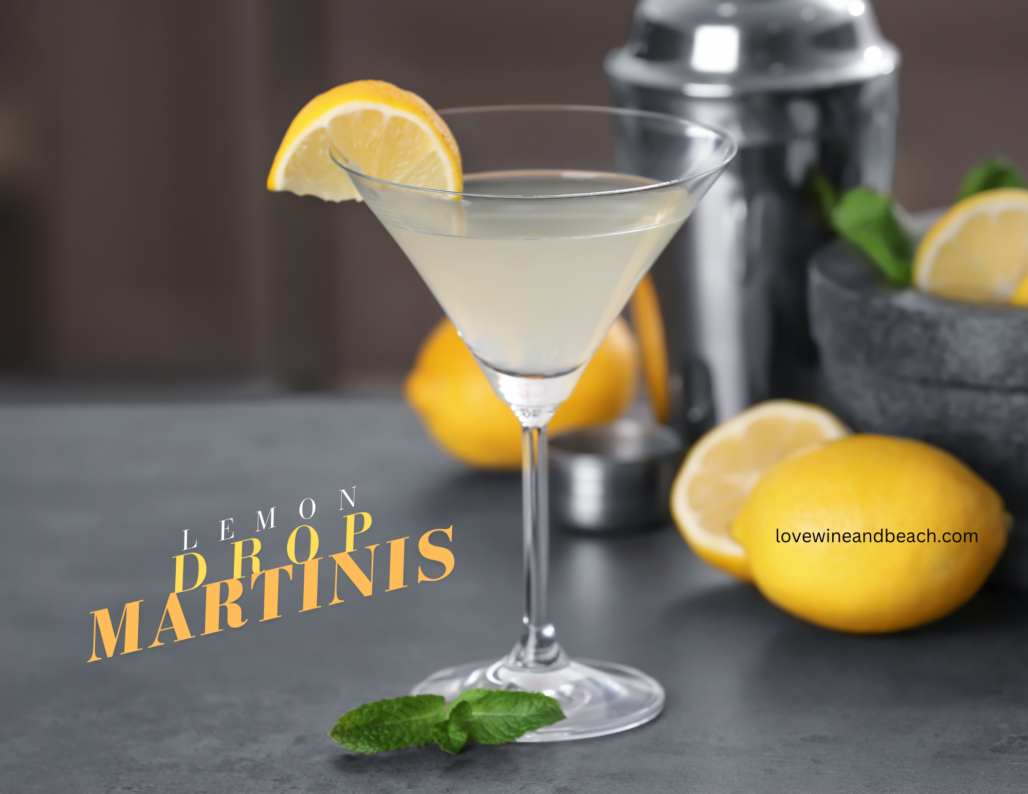 Lemon drop martini with lemons on the counter with a silver shaker